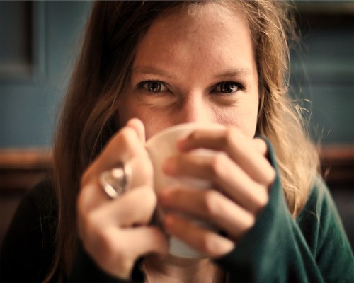 Smiling mature woman holding a cup of tea outdoors